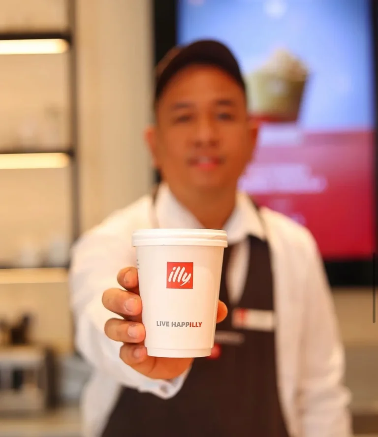 Barista holding illy takeaway cup — MICC International photography